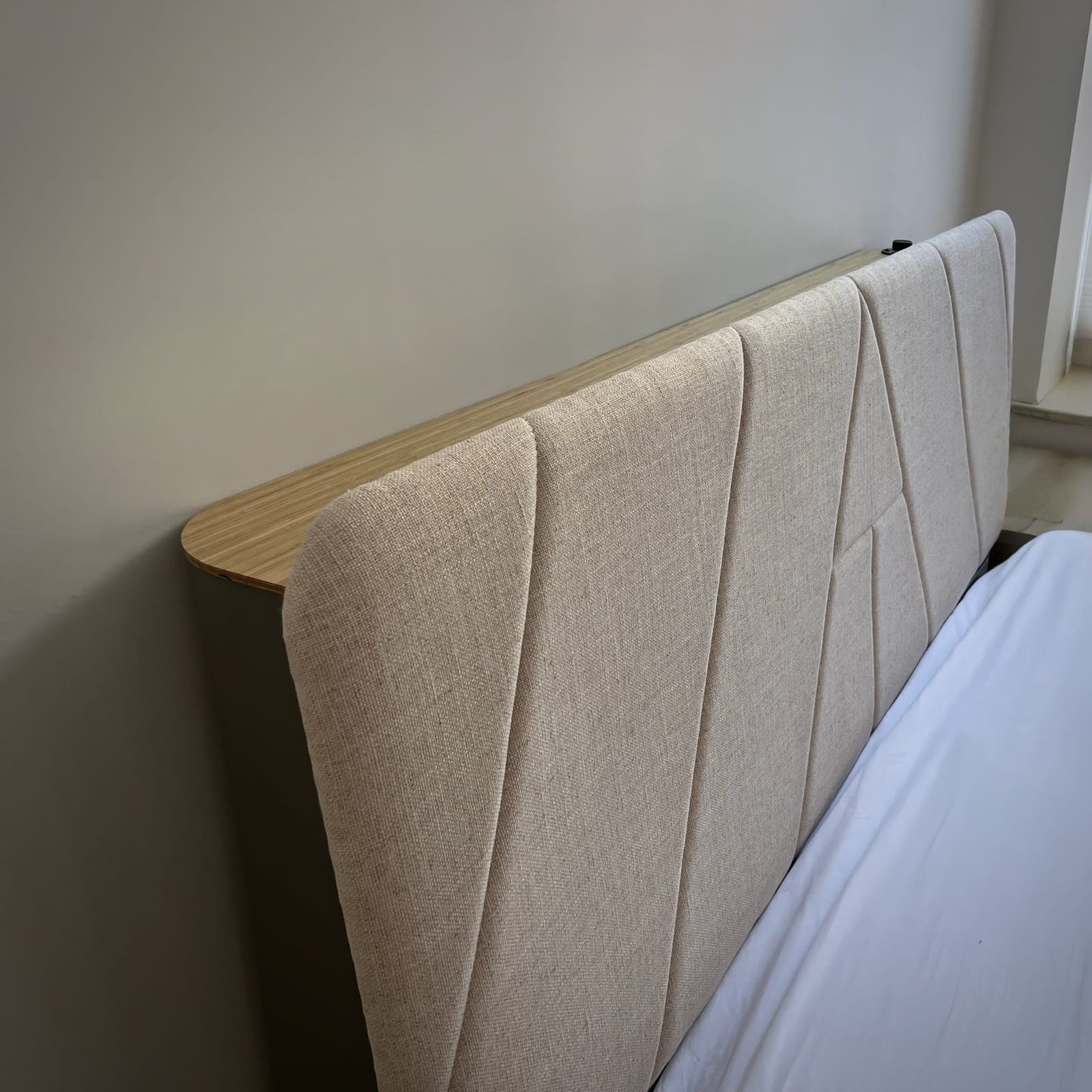 AirTulip Sleep upholstered headboard with an air purifier built into the panel, shown behind a made bed