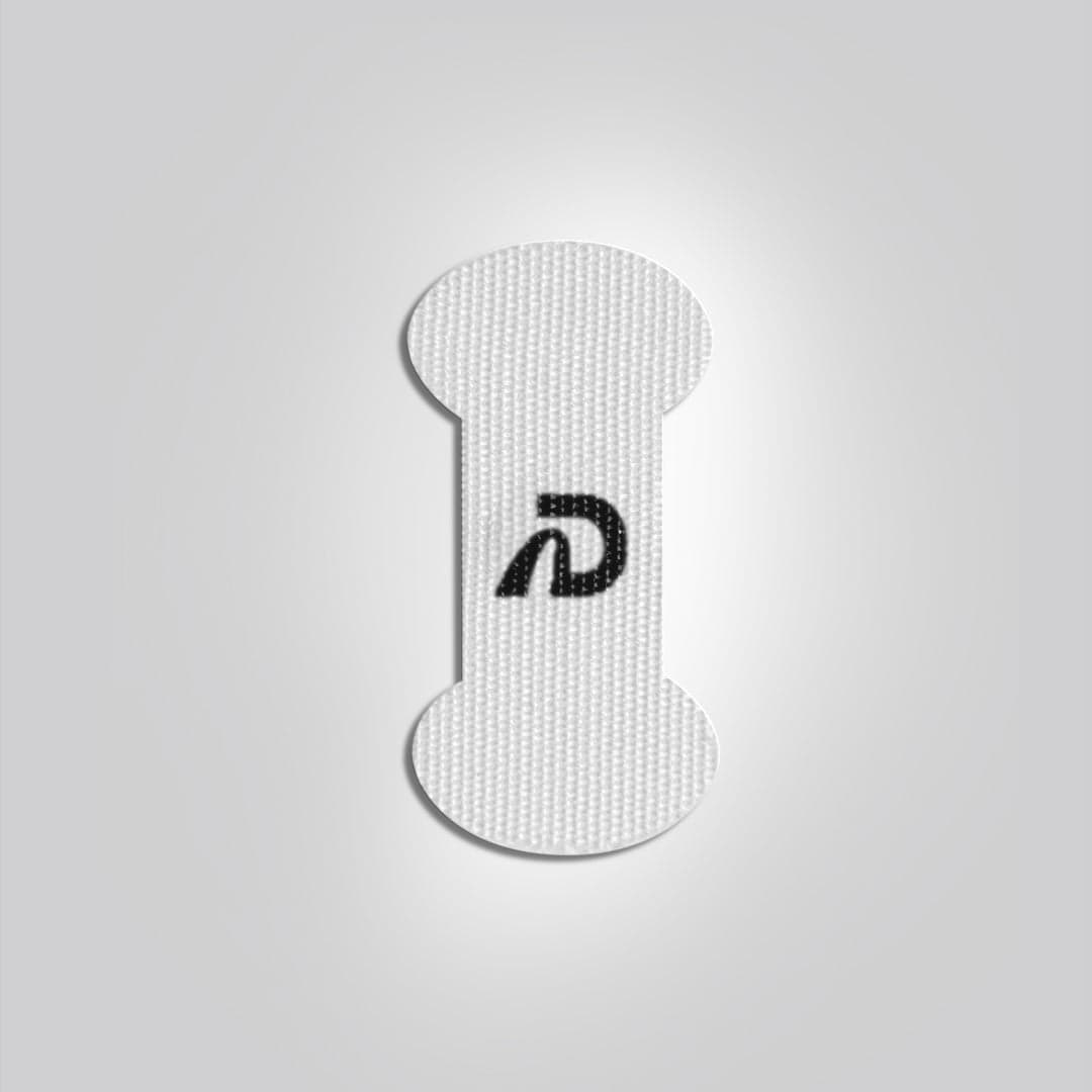 Dream Recovery Dream Tape mouth tape strip in white, vertical with rounded ends and a black D logo in the middle, on a plain light grey background