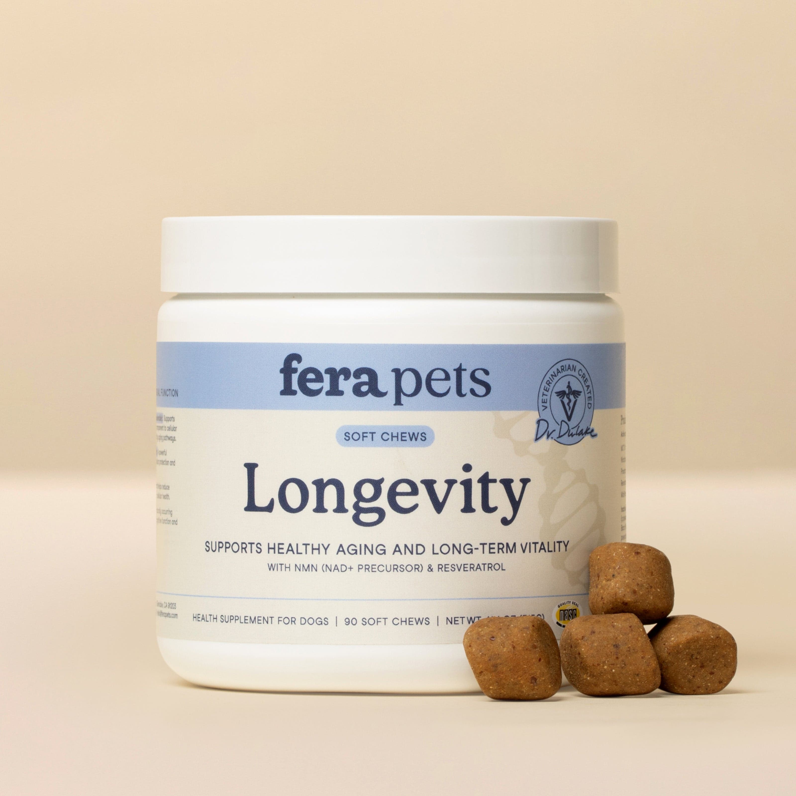 White Fera Pets Longevity soft chew jar with a blue band label and four square brown chews stacked in front of it on a beige background