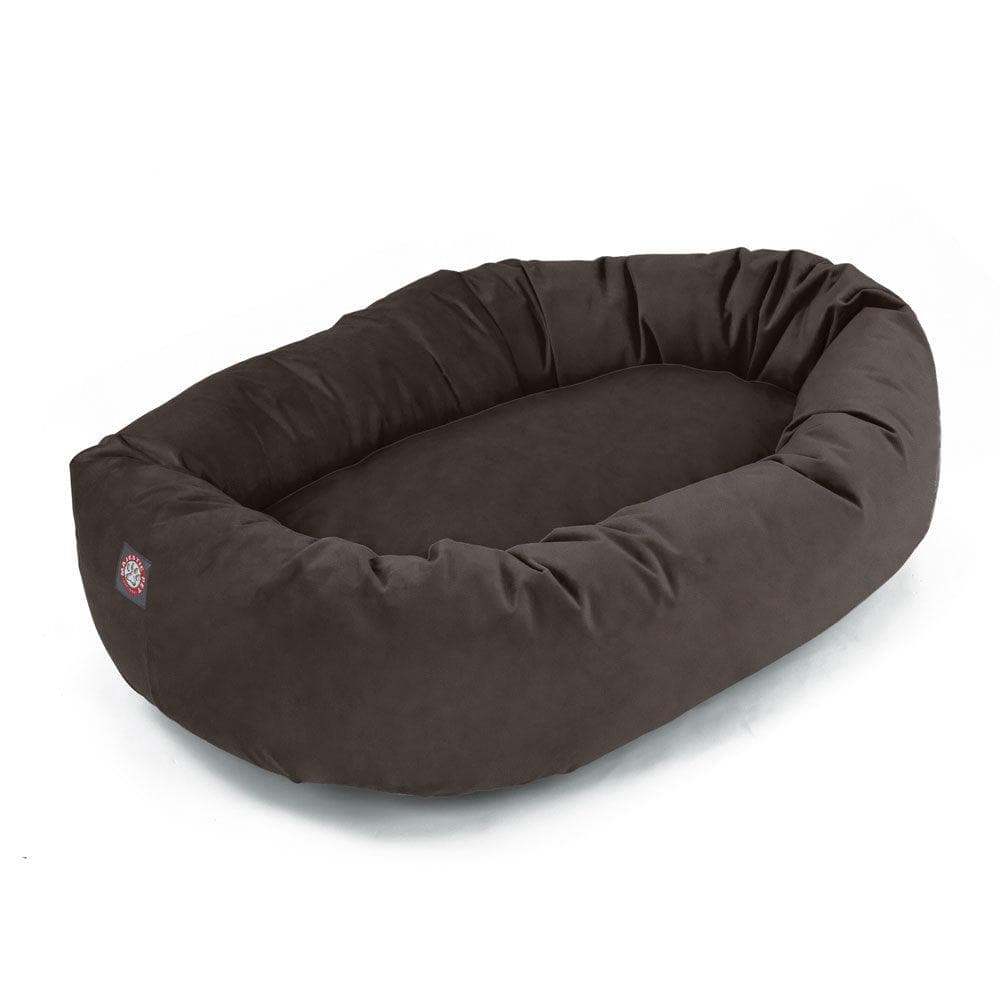 Majestic Pet Suede Bagel Dog Bed in chocolate brown faux suede, an oval bed with a bolster, seen from above at a three quarter angle on white, with a small red label on the bolster
