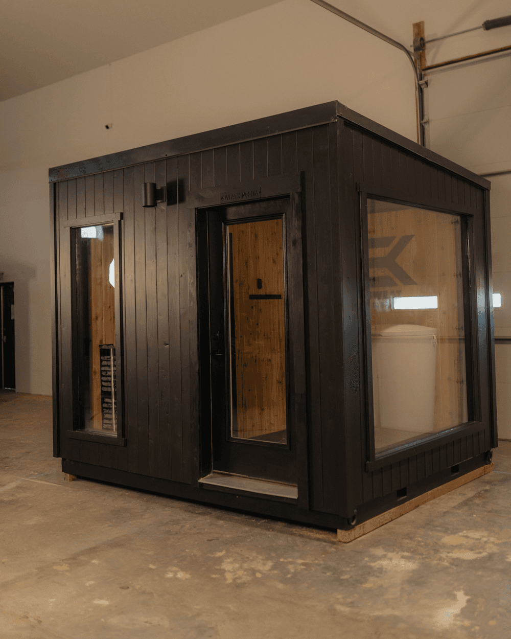 Sweat Kingdom SK Contrast pre-built sauna and cold plunge building with black exterior, glass door and picture windows
