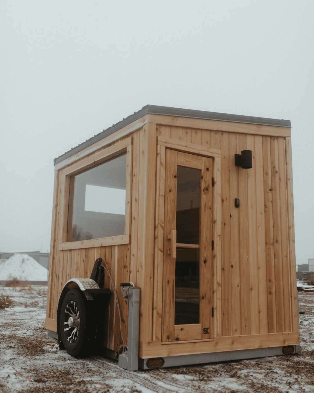 Sweat Kingdom SK Mobile cedar sauna cabin with glass door and picture window on a wheeled trailer frame